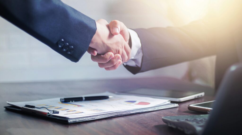 pexels photo 4175028 4175028 Professional handshake agreement over business charts in an office setting.